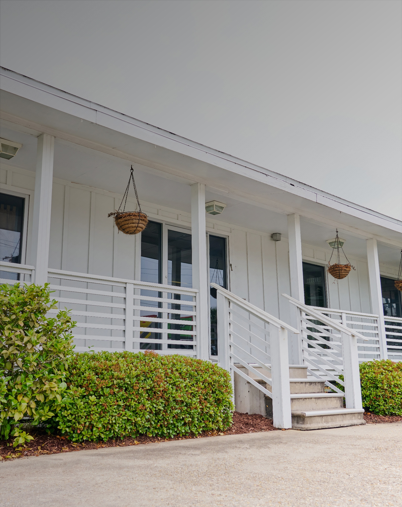Maintained property exterior with trimmed hedges cared for by Sawtooth Design LLC in Metairie, LA